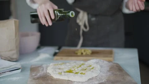 Baker pours olive oil over bread dough Stock Footage 329432832
