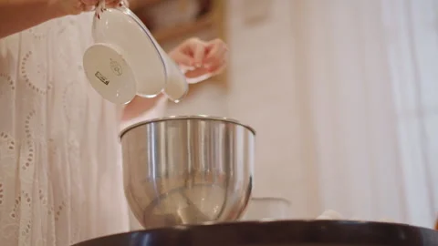 Baker prepares pumpkin batter. Pouring milk into bowl with lace sleeve. Closeup Stock-Footage 346394103