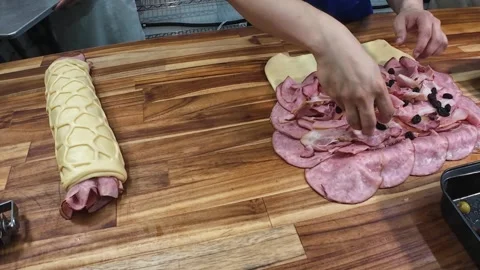 Baker preparing authentic Venezuelan ham bread by adding raisins and syrup Stock Footage 336887322