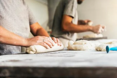 Baker preparing bread. Close up of hands kneading dough. Stock Photos
