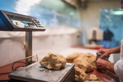 Baker preparing bread with dough on a scale Stock Photos
