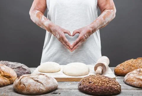 Baker preparing delicious fresh bread and pastry Stock Photos