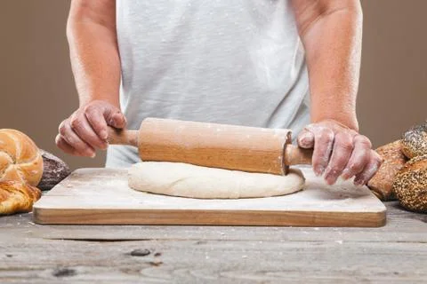Baker preparing delicious fresh bread and pastry Stock Photos
