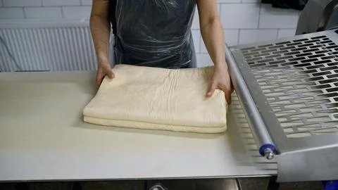 Baker preparing dough for baking in bakery workshop. Stock Photos