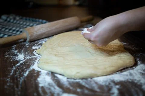 Baker preparing dough on kitchen table. Homemade pastry making process. Stock Photos