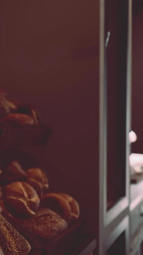 Baker preparing fresh bread in a warm bakery during morning hours Stock Footage 342184477