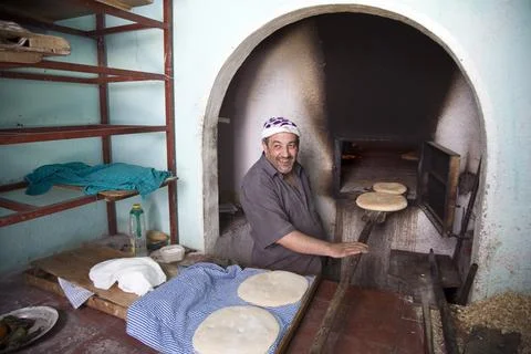 Baker Preparing Traditional Bread in Communal Oven in Chefchaouen Morocco Foto stock