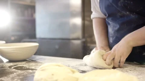 Baker Pressing Dough on Floured Counter, Sunlit Artisan Bakehouse, Medium Shot Stock Footage 341339911