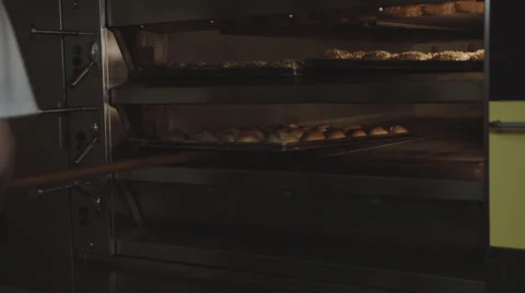 Baker pulls Bread out of the oven Stock Footage 66447828