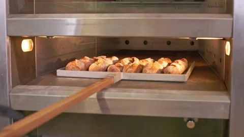 The baker pulls the hot baguettes out of the oven. Stock Footage 155522903