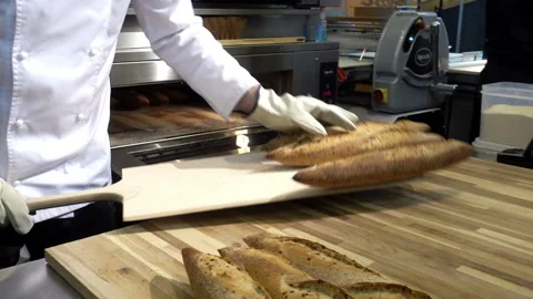 Baker pulls out freshly baked baguettes from the oven. Stock Footage 104051467