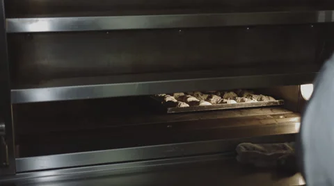 Baker pushes Bun into the oven Stock Footage 66438417