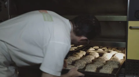 Baker pushes Bun into the oven Stock Footage 66438853