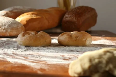 Baker put two buns on the table, tracking shot Stock Footage 10735042