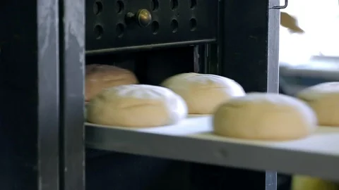 A baker puts bread into an industrial oven at a bakery 스톡 동영상 89576098