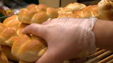 A baker puts bread rolls on a shelf in a bakery - closeup 库存影片 103091320