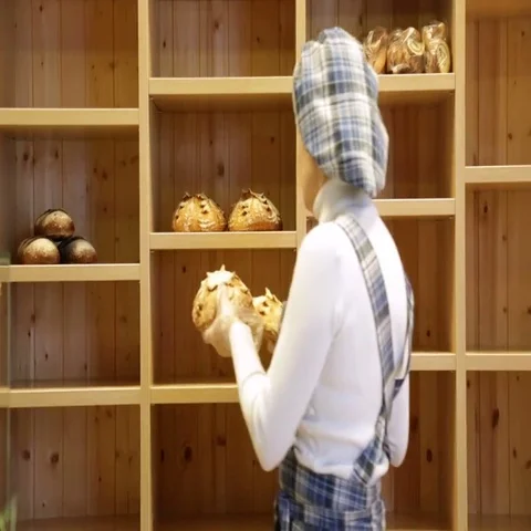 The baker puts bread on the shelves of his store Stock Footage 69484595
