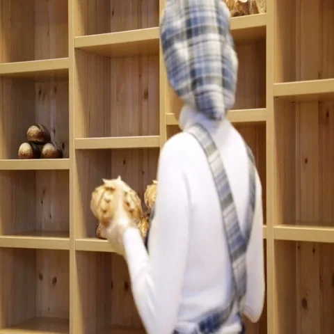 The baker puts bread on the shelves of his store Stock Footage 69484814