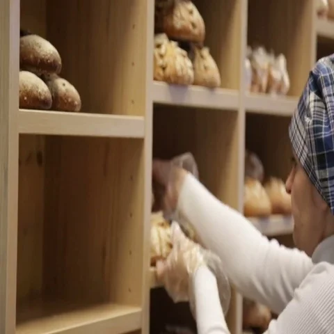 The baker puts bread on the shelves of his store 動画素材 69484862