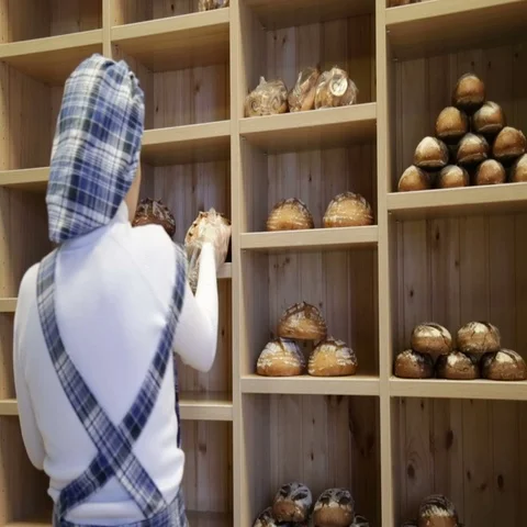 The baker puts bread on the shelves of his store Stock Footage 69485009