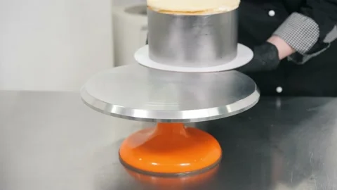 Baker puts cake in baking dish on elegant stand at table Video stock 138727762