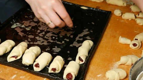 Baker puts croissants on the baking tray pan Stock Footage 61197162