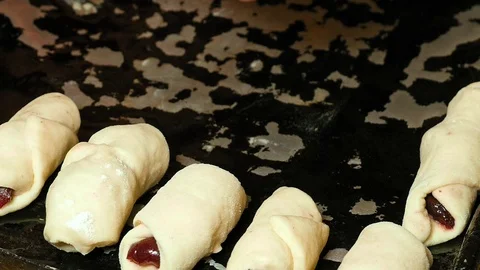Baker puts croissants on the baking tray pan Stock Footage 69980254