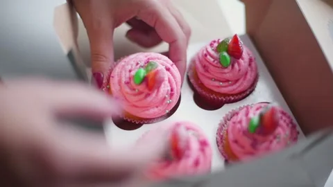 Baker puts cupcakes into the box Stock Footage 143585421