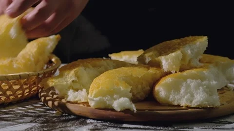 A baker puts fresh broken bread into a basket, close-up. Stock Footage 150308542