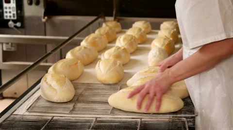 Baker puts hot fresh white bread from the oven to the iron tray Vídeos de archivo 64471145