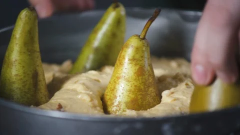 Baker puts pears in cake dough lying in a baking dish. Pie and bakery products. 스톡 동영상 124752036
