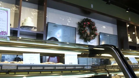 Baker putting cakes into a display case 動画素材 77080128