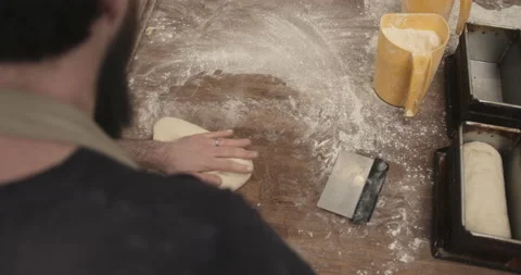 Baker putting dough for loaf of bread in oven tray in bakery kitchen Stock Footage 150530905