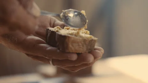 Baker putting a spread onto piece of bread and tasting it Stock Footage 274679929