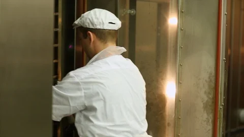 Baker removes a rack of bread from a oven Stock Footage 105080804