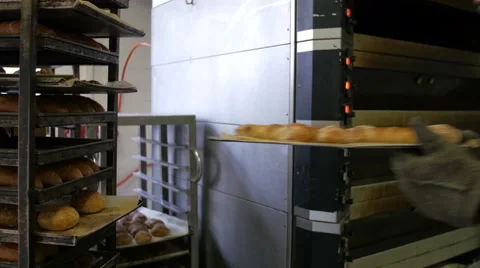 Baker Removing Baked Bread from Oven at Factory Stock Footage 51344461