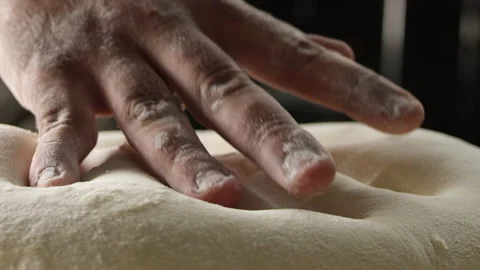 Baker removing hand from dough on counter Stock Footage 274688936