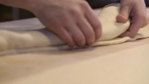 Baker rolling croissant dough on a table Stock Footage 87613048
