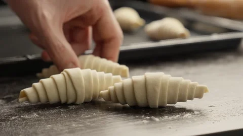Baker rolling croissant dough. Working with dough. Bakery concept. Homemade Stock Footage 297054861