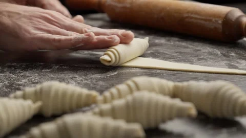 Baker rolling croissant dough. Working with dough. Bakery concept. Homemade Stock Footage 297603868