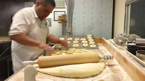 Baker Rolling Dough and Preparing Donuts in Commercial Bakery Stock Footage 331846180