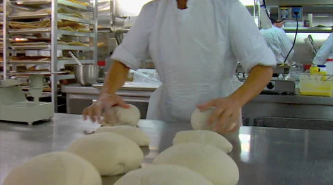 Baker rolling dough in industrial bakery kitchen Stock Footage