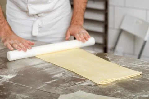 Baker is rolling dough out using a pin Stock Photos
