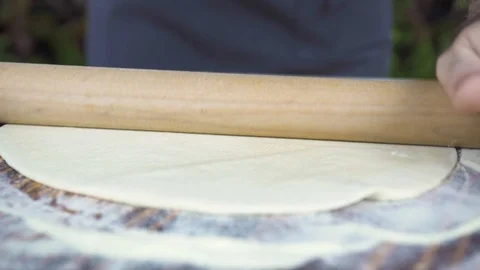 Baker rolling dough with roller for cake baking on bakery kitchen. Closeup. Chef Stock Footage 98817013