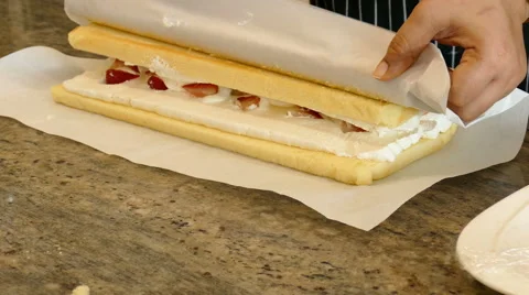 Baker rolling up fruit roll on table Stock Footage 65968020