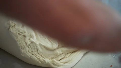 Baker rolling large piece of dough and making bread. Professional baker Stock Footage 148656436