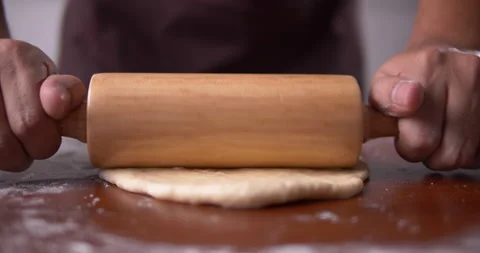Baker rolling pizza dough on table before baking. Vídeo Stock 138288800