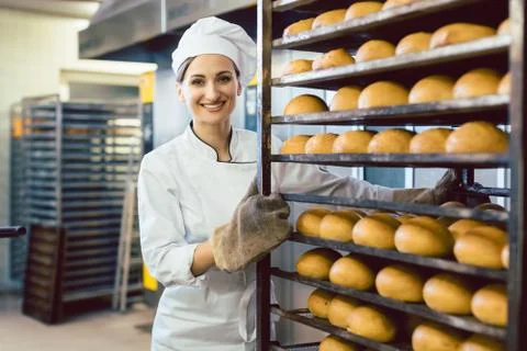 Baker rolling trays with fresh bread thru the bakery Stock Photos