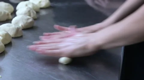 Baker rolls the dough and wrap a sausage in it Stock Footage 58854340