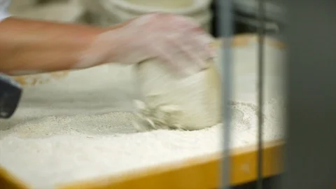 Baker rolls dough into flour Stock Footage 105080749